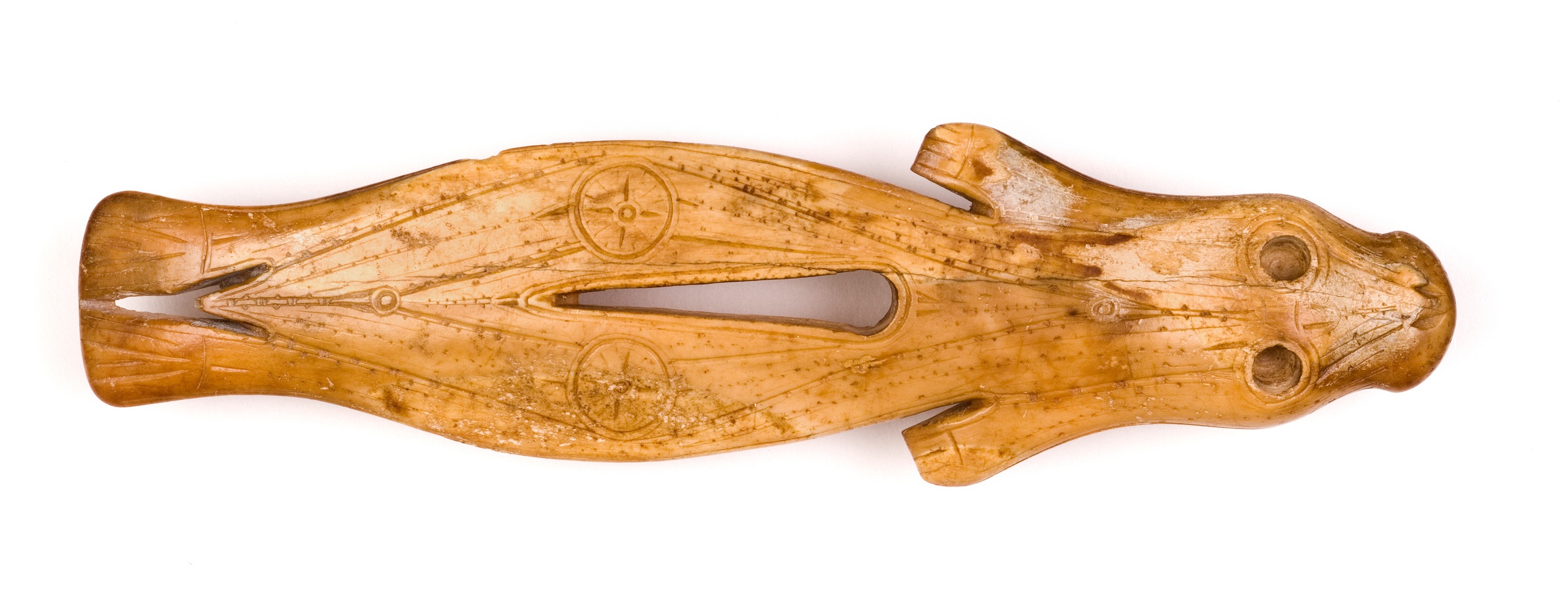 Пластина в виде фигурки нерпы. Первое тысячелетие н. э.Эквен, Чукотка, древние эскимосыМоржовый клык, резьба, гравировка. Длина 9,4 смГосударственный музей искусства народов Востока