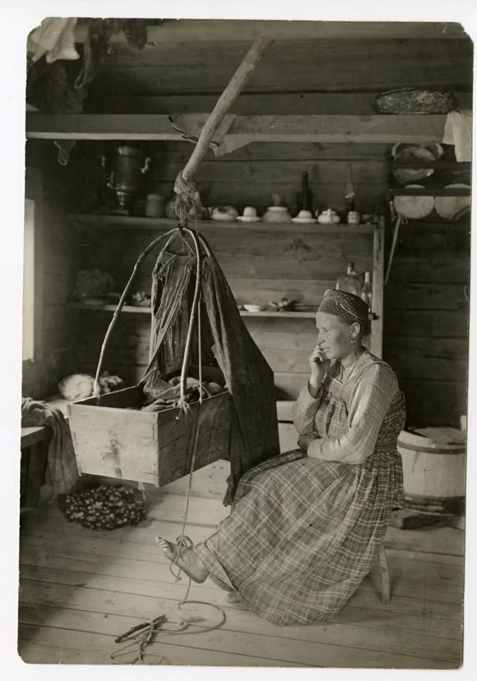 Анатолий Павлович. Женщина в избе качает колыбель (зыбку). Деревня Яреньга. 1910. Предоставлено Ваней Мишиным